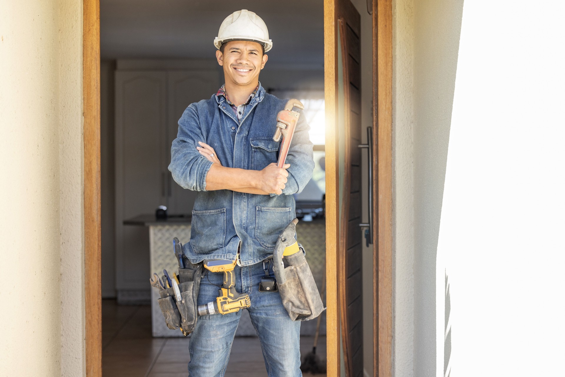 Handyman in portrait, maintenance and tools with construction and home renovation, builder with smile. Professional, contractor and DIY skills, architecture and wrench, male with helmet for safety